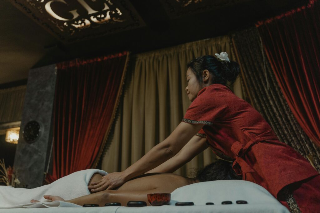 A peaceful massage session with a therapist providing a traditional Asian massage indoors.